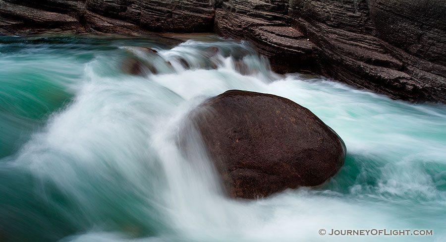 A lone rock holds against the rush of the water at Maligne Canyon in Banff National Park, Alberta, Canada. - Banff Photography