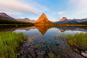 A scenic landscape photograph of sunrise on Swiftcurrent Lake, Glacier National Park, Montana. - Northwest Photograph