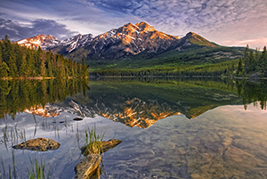 Morning light bathes Pyramid mountain in Jasper National Park.The scene is nearly perfect reflected in the still waters of Pyramid Lake. - Canada Photograph