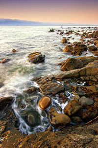 Close to the northwestern most tip of the continential United States, the waves of the Strait of the Juan de la Fuca lap against the rocks. - Pacific Photograph