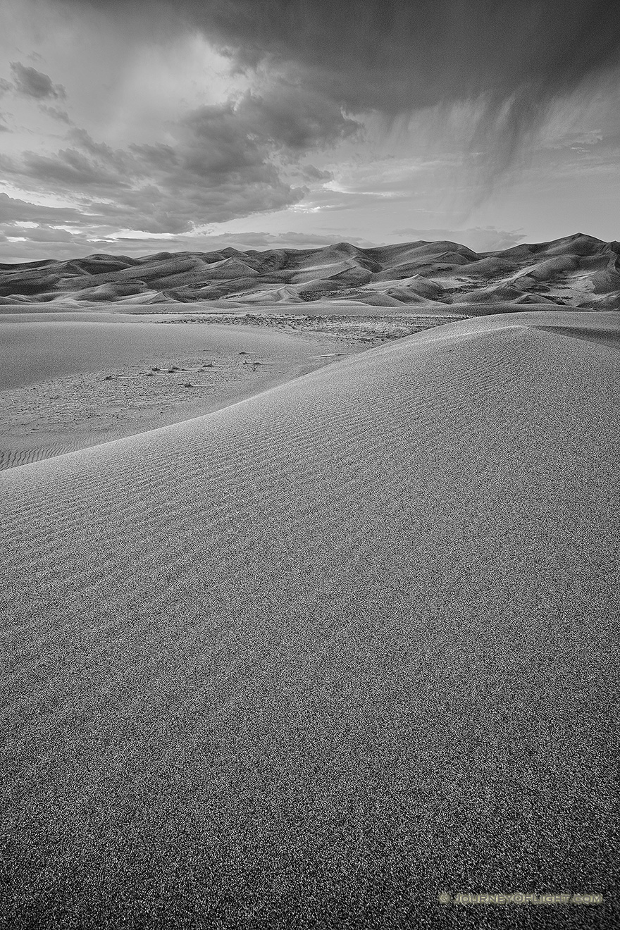 Clouds from a storm rolling through the Great Sand Dunes almost touch the top of the dunes. - Great Sand Dunes National Park Picture