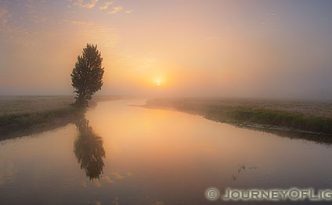The Gibbons River quietly flows through Elk Meadow as the last of the morning fog is burned off from the rising sun.