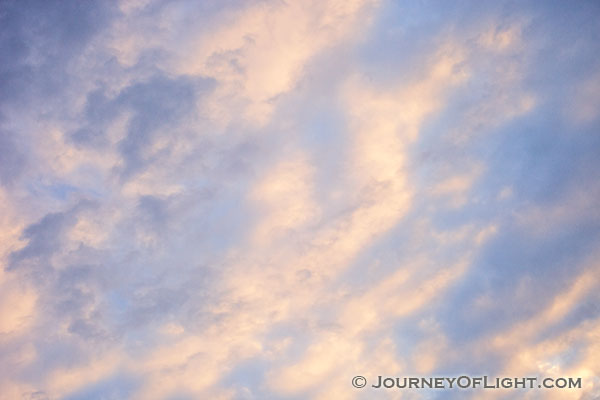 Light from the setting sun illuminates clouds in an abstract pattern on a chilly February evening.