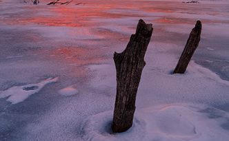On a chilly February evening the setting sun illuminates the clouds in the western sky with a dazzling crimson color.