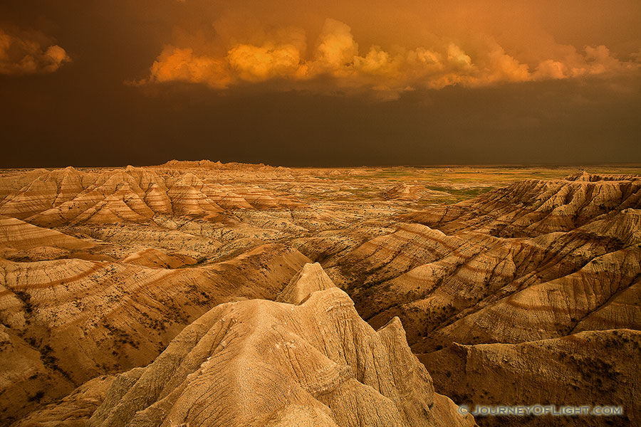 Facing east, the sky was nearly pitch black shrouded by the fierce storm that had just passed through. As the sun dipped below the horizon the last rays hit the trailing storm clouds and the ambient warm light lit up the valley across the Badlands in South Dakota.