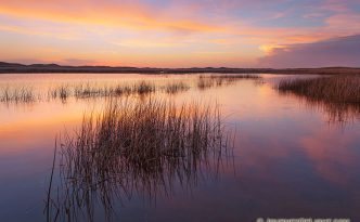 Dusk Over Perrin Lake On a cool and quiet spring evening, the sun illuminates the clouds hanging over Perrin Lake at Crescent Lake National Wildlife Refuge in the Sandhills of Nebraska. Pinks and Oranges reflected in the lake as ducks quacked in the distance.