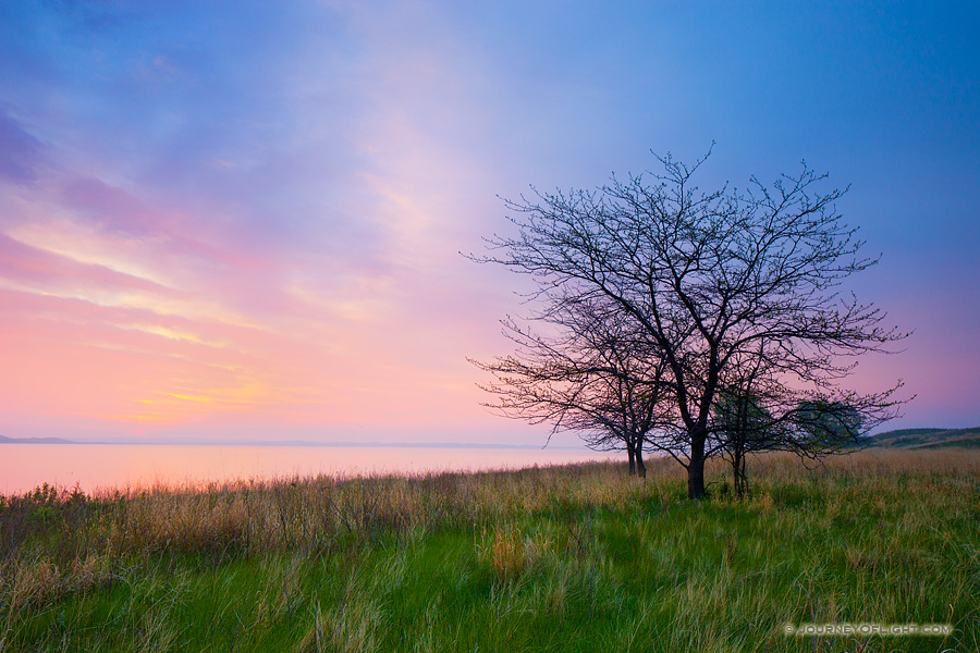The spring rains often make the sandhill region of Nebraska a verdant green. It is one of my favorite times to become lost in the sea of grass in the central part of the state. On this beautiful morning I wandered out to North Marsh Lake in the Valentine National Wildlife Refuge and waited as the sun rose on the distant horizon illuminating the clouds in pastel pinks, oranges, and purples.
