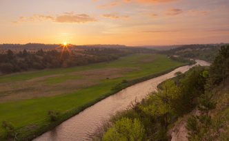 The Niobrara is one of the most popular rivers for canoeing and tubing in the United States. On a beautiful spring sunrise, the river lazily meanders into the east as the sun rises in the distance.