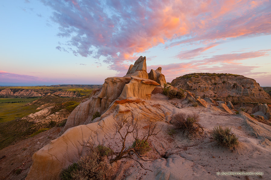 The warm glow of the rising sun illuminates badlands in western North Dakota in Theodore Roosevelt National Park. 