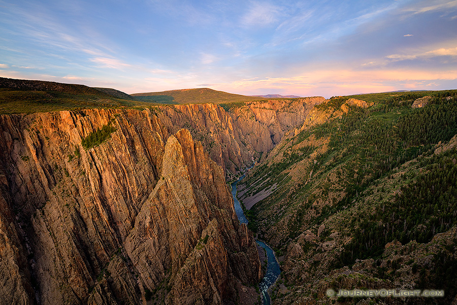 As the sun sets in the west in Black Canyon of the Gunnison National Park, the last glow of the day skims the canyon walls to the east.