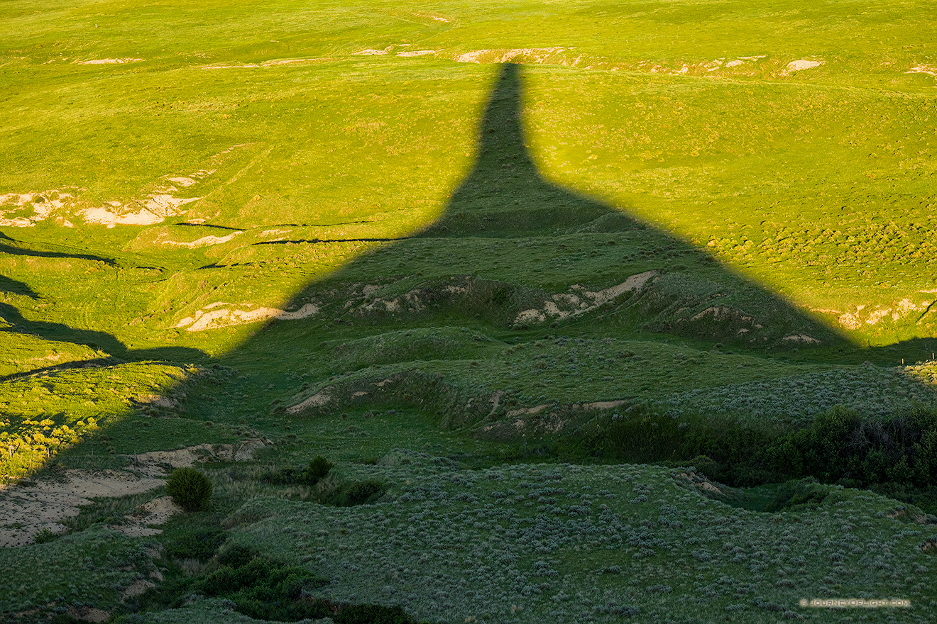Chimney Rock's shadows stretches out across the plains as the sun dips low in the western sky.