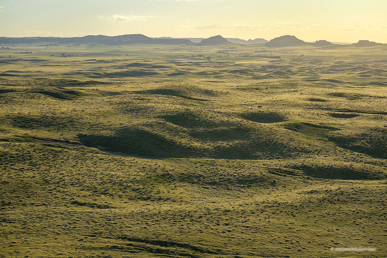 To the west of Chimney Rock the sky glows warm with the light of the setting sun.