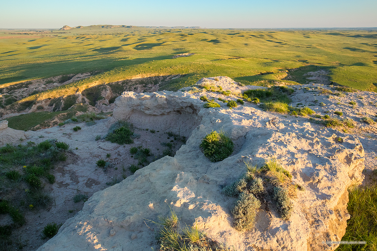 From high on Courthouse Rock a great expanse of the Nebraska Plains to the west are illuminated by the warmth of the rising sun.
