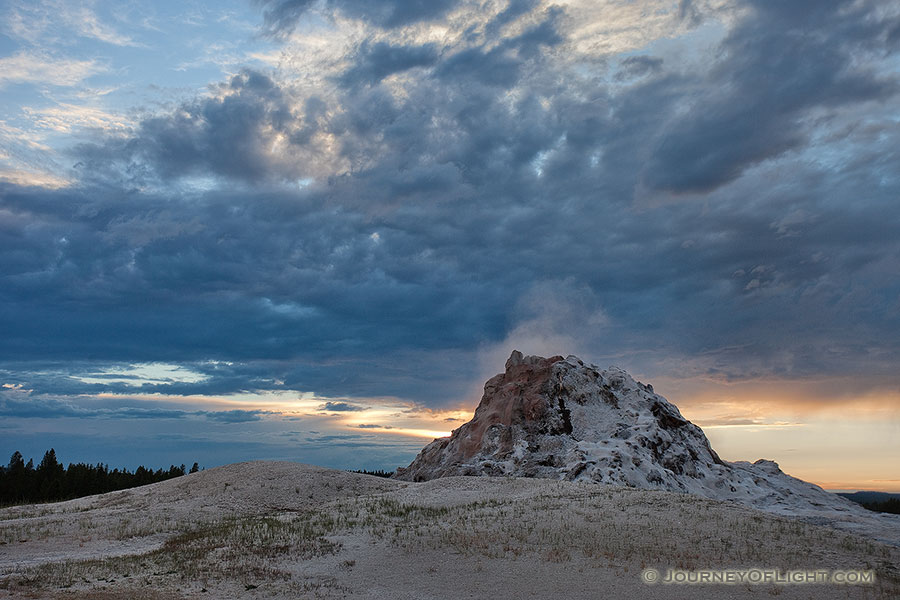 Castle Geyser steams as a storm front approaches in the late evening at Yellowstone National Park in Wyoming. - Yellowstone National Park Photography