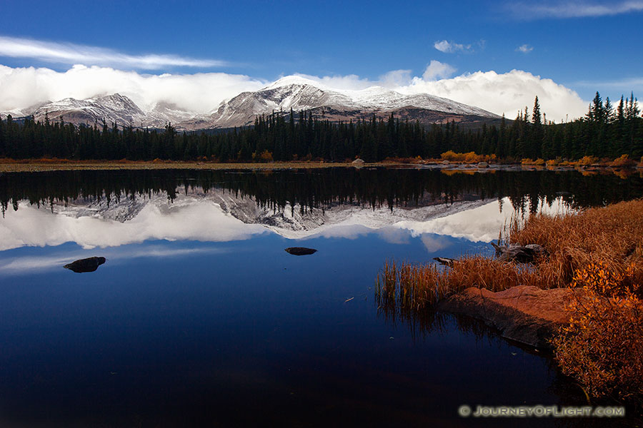 Just after a short storm rolled through, Red Rock Lake was still reflecting the mountains and clouds in the distance. - Colorado Photography