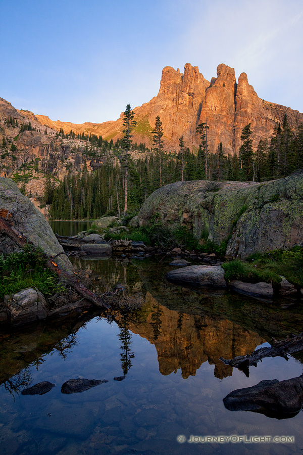 The summer sun shines a warm glow on Ptarmigan Mountain it's reflection in an outlet of Lake Nanita below. - Colorado Photography