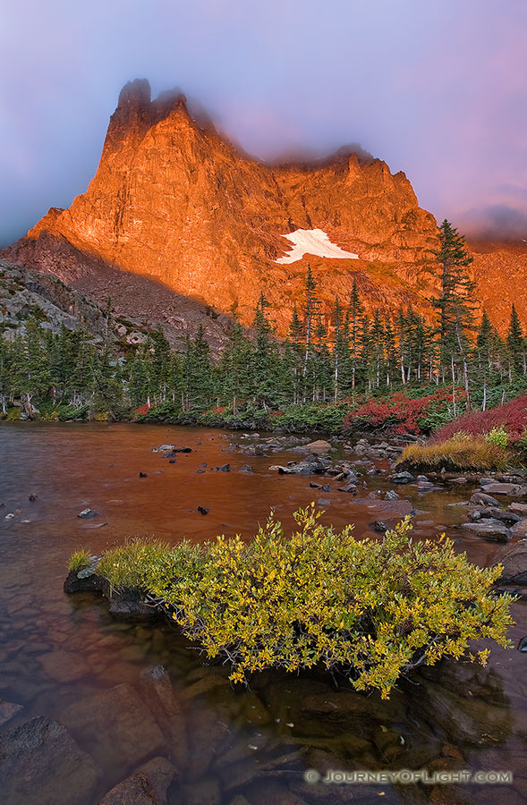 One of my favorite lakes in Rocky Mountain is Lake Helene.  About 2 and a half miles from Bear Lake, this spot is nestled at the bottom of Notchtop Mountain.  On a September day, the leaves on the bushes have turned a bright crimson hue and the early morning fog begins to dissipate quickly as the the mountain glows with the advent of a new dawn.  It is serenity and peacefulness with only the rustling of the trees and the occasional chirp of a Stellers Jay. - Rocky Mountain NP Photography