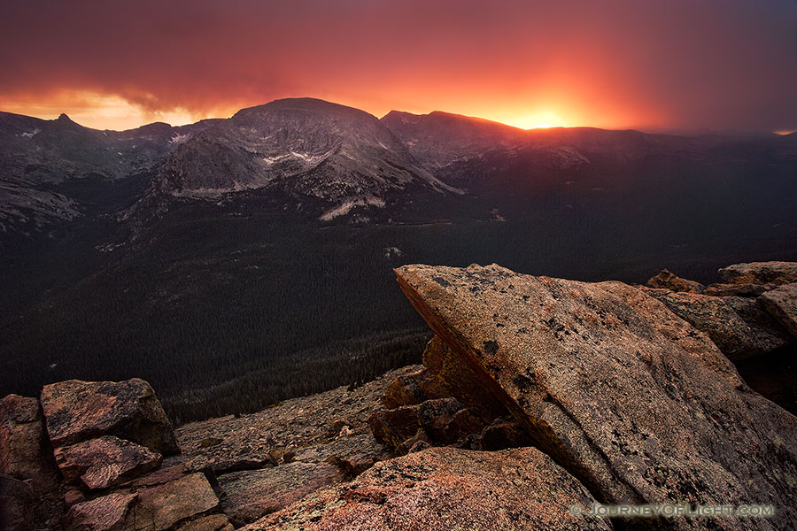 The sun shines brightly for one last minute before setting illuminating the clouds during a snowstorm at the Forest Canyon Overlook at Rocky Mountain National Park. - Rocky Mountain NP Photography