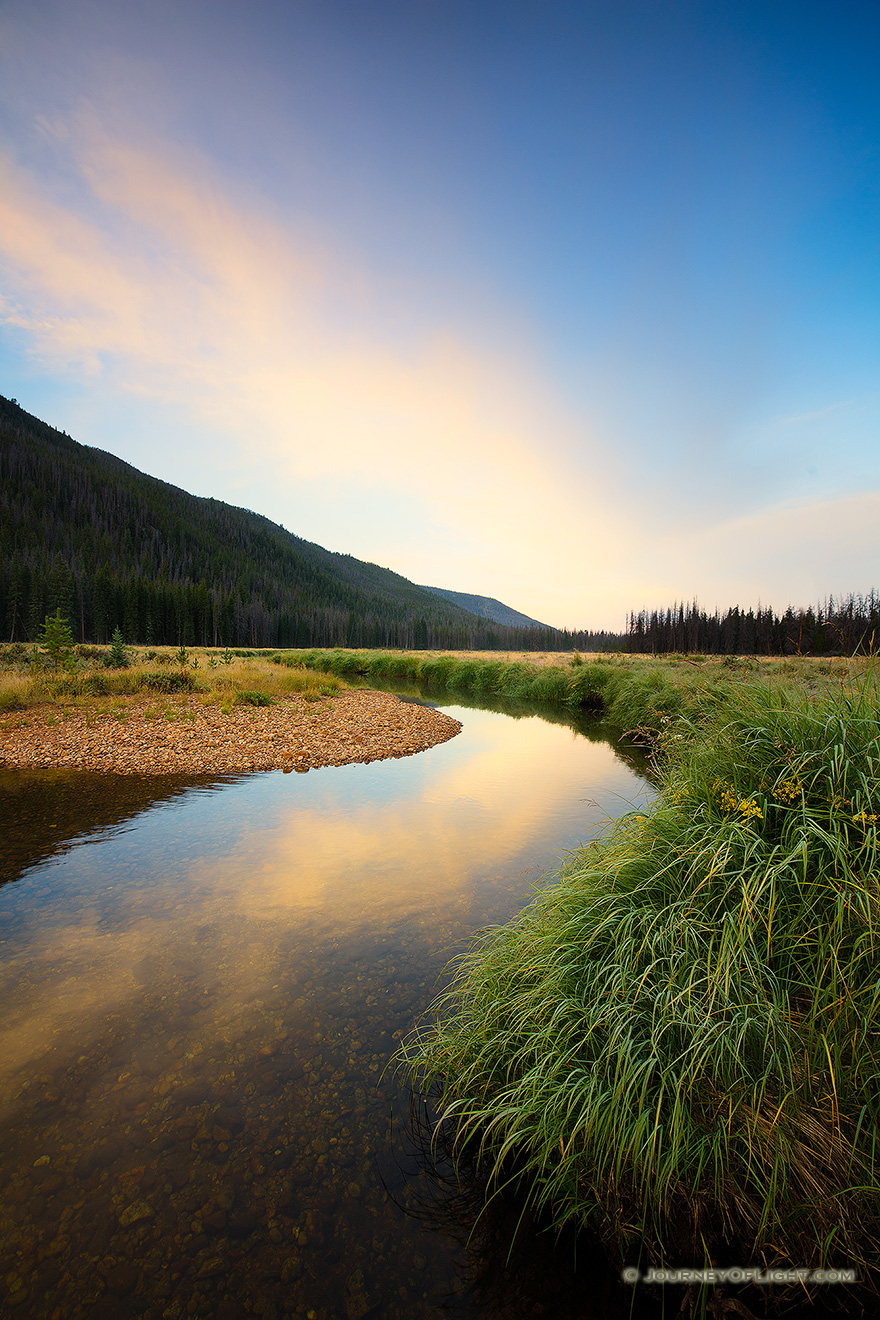 On the west side of Rocky Mountain National Park, the North Inlet stream snakes through a meadow and reflects a beautiful autumn sunrise. - Colorado Picture