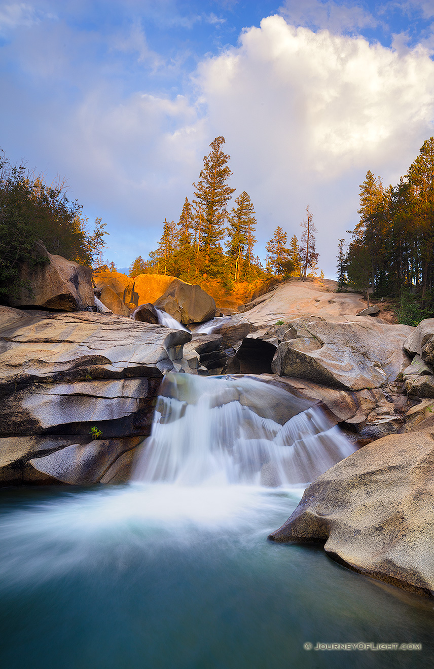 The soothing swoosh of the waterfall was the other sound as the warm last light strikes trees above the Grottos Waterfall in the White River National Forest in Colorado. - Colorado Picture