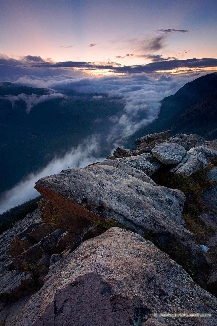 Clouds gather in the valleys of Rocky Mountain National Park as the sun sets in the distance. - Rocky Mountain NP Picture