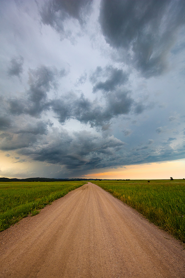 A landscape photograph of an intense summer storm rages over a rural country road in South Dakota. - South Dakota Photography