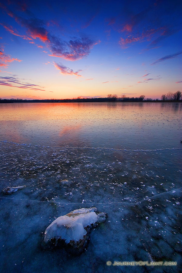 This photograph was captured in the dead of winter, when the old Missouri River oxbow at DeSoto National Wildlife Refuge transforms into a reflective sheet of ice with a single rock still visible. - DeSoto Photography