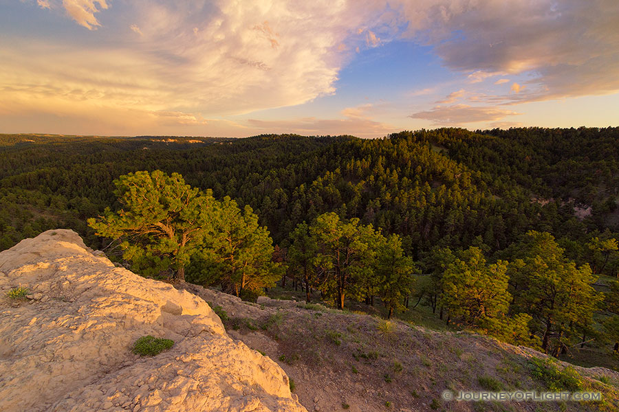 In the extreme Northwestern edge of Nebraska, north of Harrison is a little WMA called Gilbert-Baker WMA.  On this cool spring evening, I hiked for a couple of miles over a few hills and then sat on this rock content to eat my dinner and watch a storm brew in the distance and then dissipate, leaving interesting clouds to reflect the light of the setting sun. - Nebraska Photography