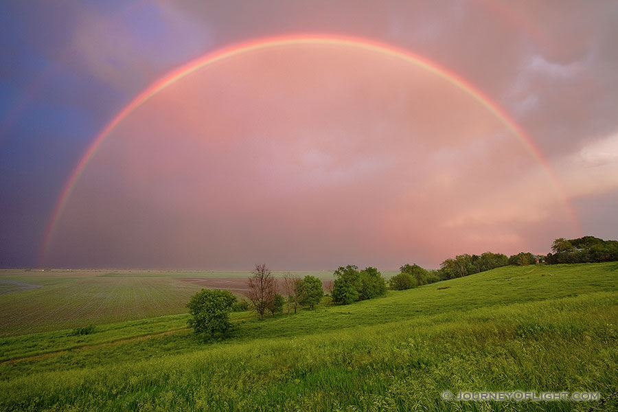 After an intense midwestern spring storm, from a Nebraska hilltop, an entire rainbow arches through the sky. - Nebraska Photography