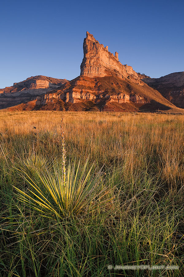 Scotts Bluff National Monument in western Nebraska.  Towering eight hundred feet above the North Platte River, Scotts Bluff has been a natural landmark for many peoples, and it served as the path marker for those on the Oregon, California, Mormon, and Pony Express Trails.  Scotts Bluff National Monument preserves 3,000 acres of unusual land formations which rise over the otherwise flat prairieland below. - Nebraska Photography