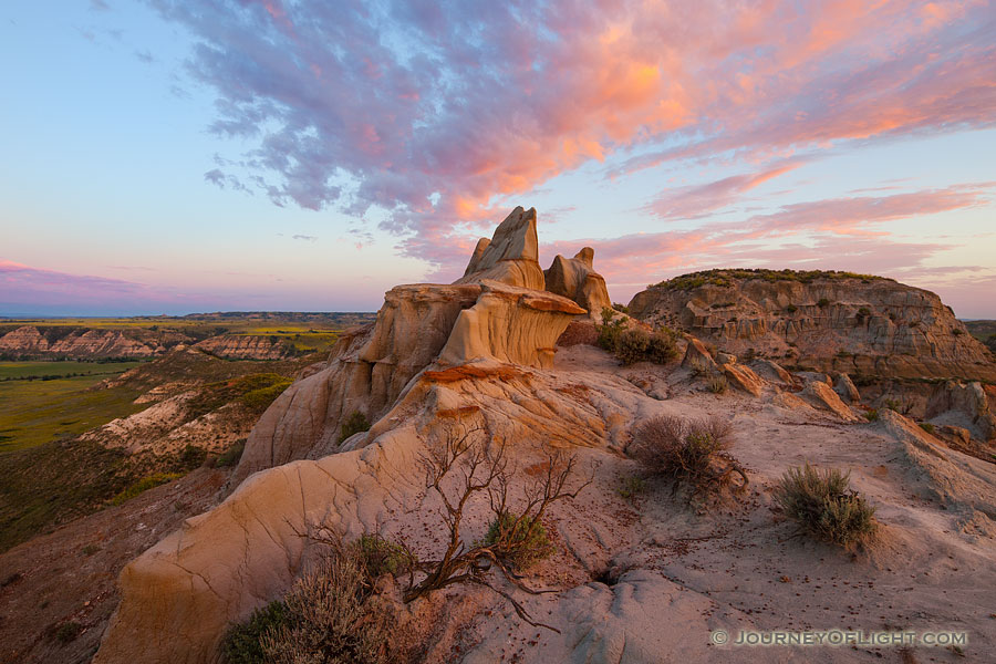 The warm glow of the rising sun illuminates badlands in western North Dakota in Theodore Roosevelt National Park. - North Dakota Photography