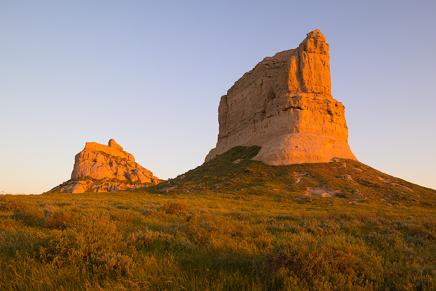 Jailhouse and Courthouse Rock both glow red with the first light at sunrise. - Nebraska Photography