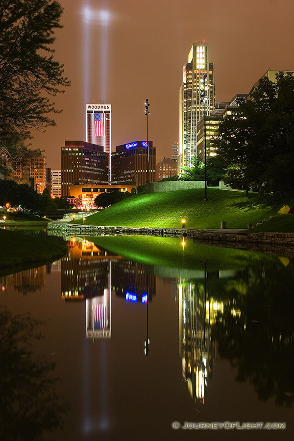 On September 11, 2006 Omaha, Nebraska paid tribute to the victims of 9/11 by hanging 2 large United States flags on the Woodmen tower and by shining two large lights into the sky. - Omaha Photography
