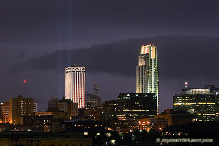 On September 11, 2006 Omaha, Nebraska paid tribute to the victims of 9/11 by hanging 2 large United States flags on the Woodmen tower and by shining two large lights into the sky.  This particular photo was taken during a spectacular fall lightning storm. - Omaha Photography
