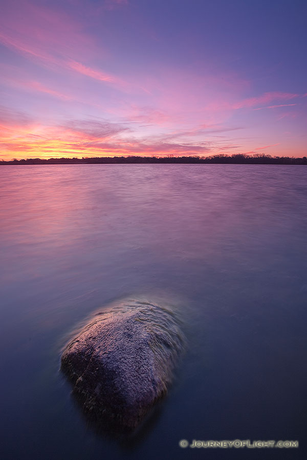 On a late Autumn morning, clouds on the horizon of Stagecoach Lake in Lancaster County, Nebraska are illuminated with bright yellows and reds. - Nebraska Photography