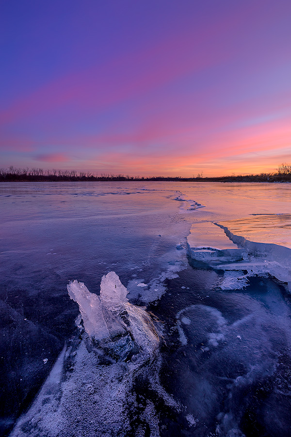 A scenic landscape photograph of the sunset over the frozen lake at DeSoto NWR, Nebraska. - Nebraska Photography