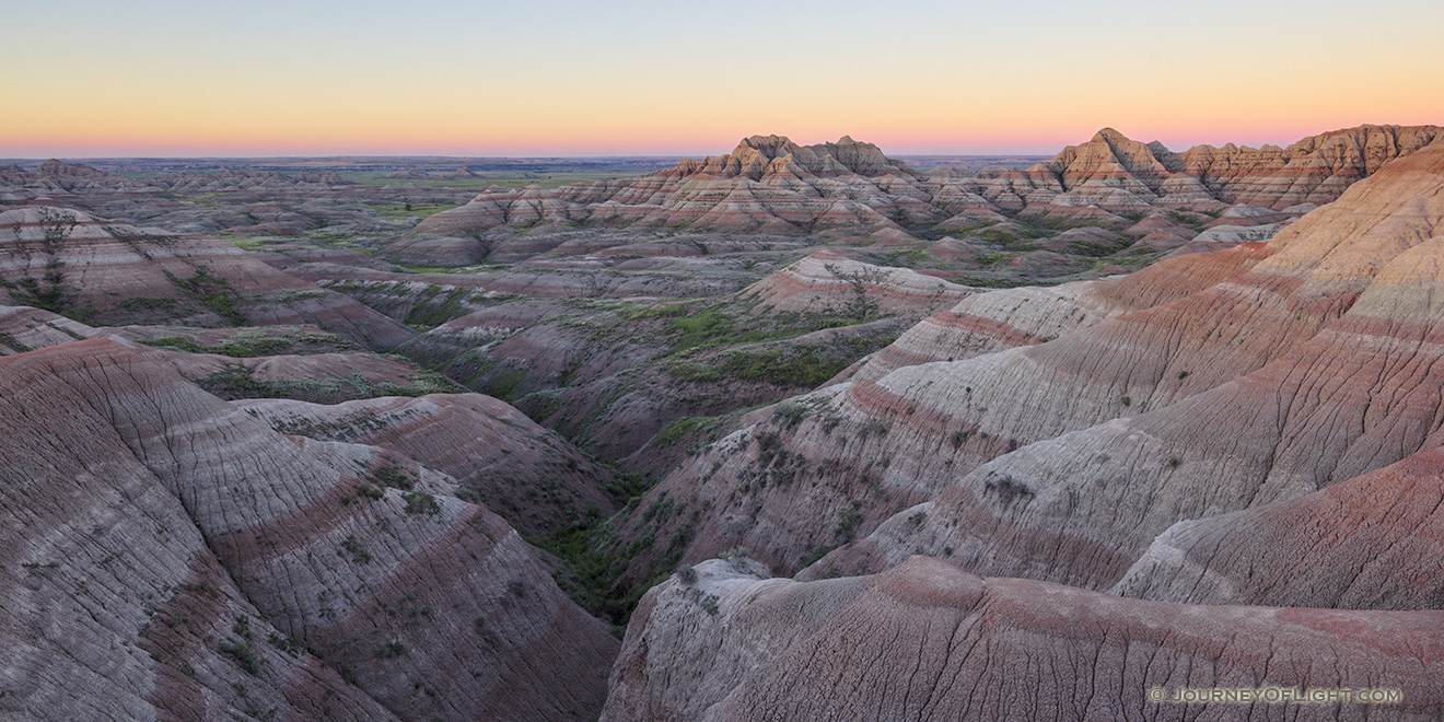 A panoramic scenic photograph of the sunrise over the Badlands National Park, South Dakota. - South Dakota Picture