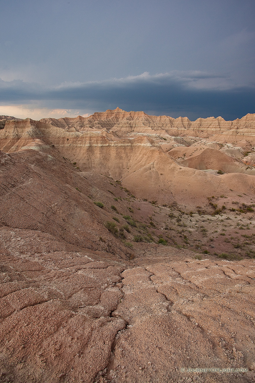 As a storm passes over Badlands National Park in South Dakota, dark clouds contrast with the desolate landscape. - South Dakota Picture