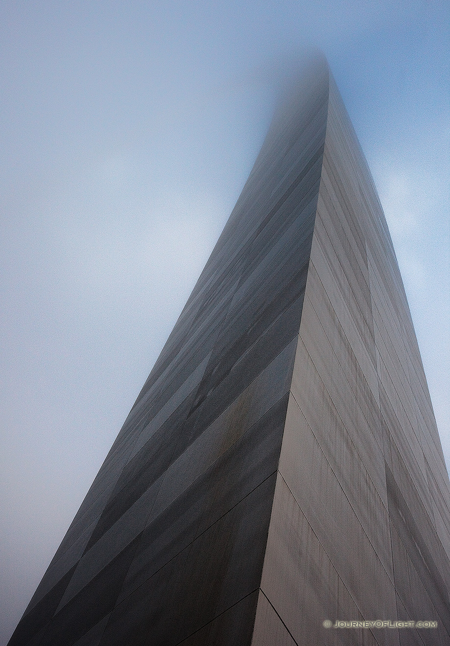 The Gateway Arch curves through the sky and into the fog.  - Jefferson National Expansion Memorial Picture
