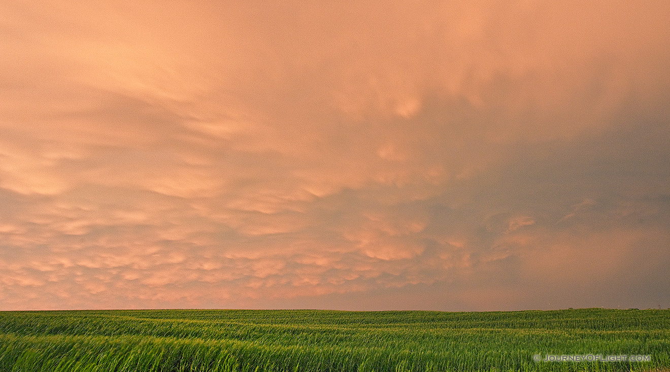 Passing ominous storm clouds reflect the red and orange hues of the sun 45 minutes after sunset. - Nebraska Picture