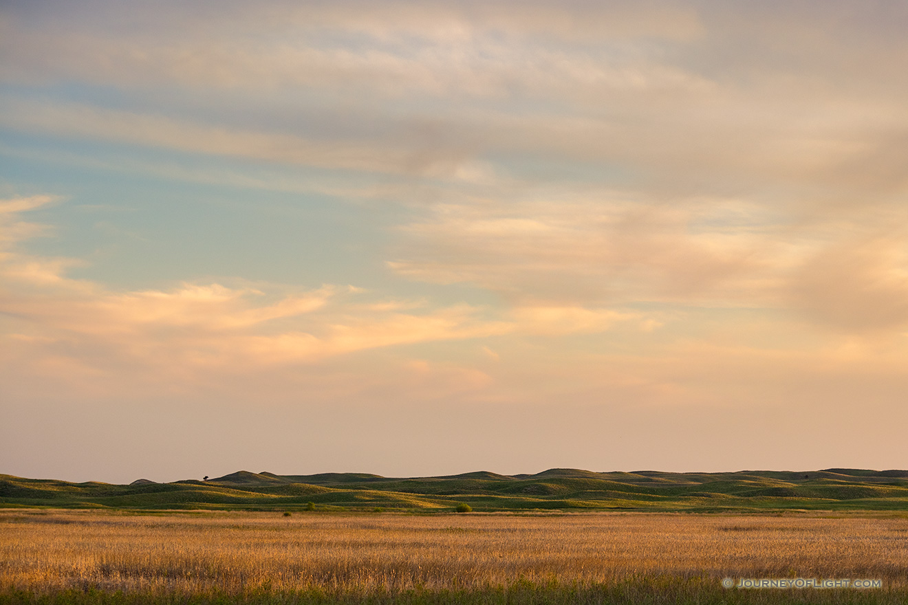 The last light of sunset skims across the Nebraska Sandhills and casts a warm glow on the clouds above. - Nebraska Picture