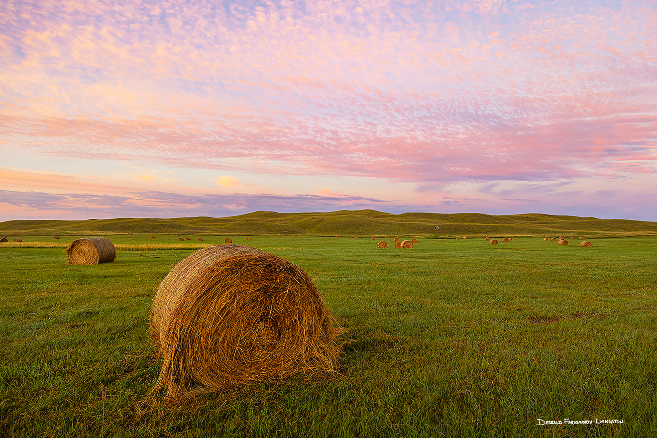 A scenic landscape photograph of hay bales under a beautiful sunrise in the sandhills of Nebraska. - Nebraska Picture