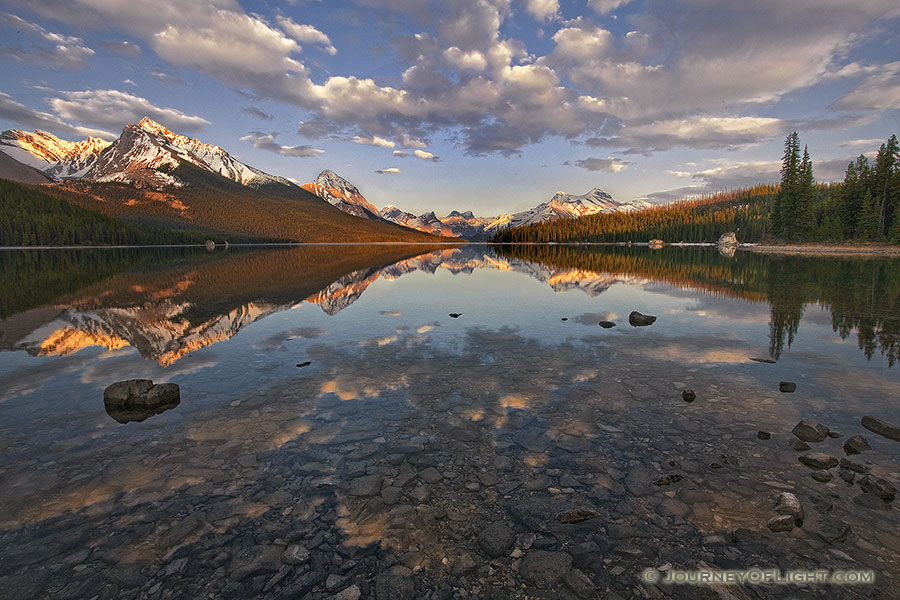 Clouds float lazily down the water as the last light hits at Maligne Lake located in Jasper National Park. - Canada Photography