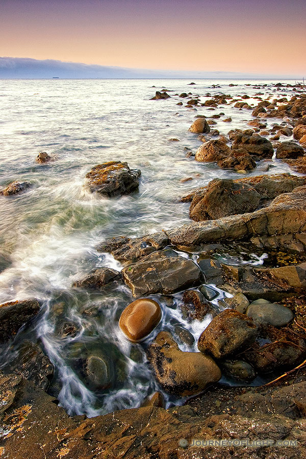 Close to the northwestern most tip of the continential United States, the waves of the Strait of the Juan de la Fuca lap against the rocks. - Pacific Northwest Photography
